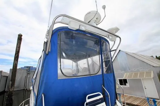 Slide: The Image of 2006 Harbor Master Coastal 400 boat with blue canopy docked at marina. - 19