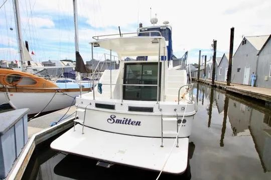 Slide: The Image of Harbor Master Coastal 400 yacht docked, rear view, named "Smitten," 2006 model. - 2