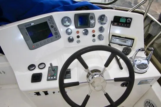 Slide: The Image of Control panel of a 2006 Harbor Master Coastal 400 boat with steering wheel and navigation instruments. - 22