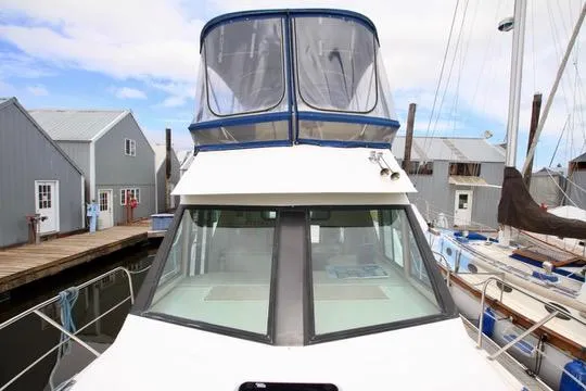 Slide: The Image of 2006 Harbor Master Coastal 400 boat docked at marina with nearby sailboats and buildings. - 30