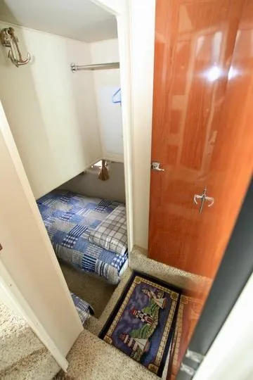 Slide: The Image of Small cabin interior with bed, wooden door, and decorative rug on a 2006 Harbor Master Coastal 400. - 39