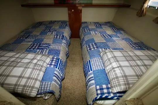 Slide: The Image of Twin beds with blue plaid bedding in a 2006 Harbor Master Coastal 400 cabin. - 45