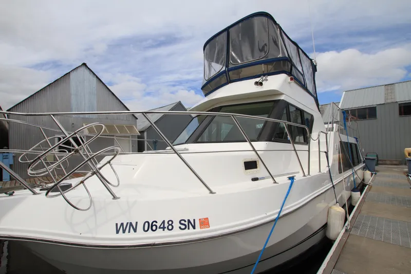 Slide: The Image of 2006 Harbor Master Coastal 400 boat docked at marina, featuring sleek design and enclosed upper deck. - 5