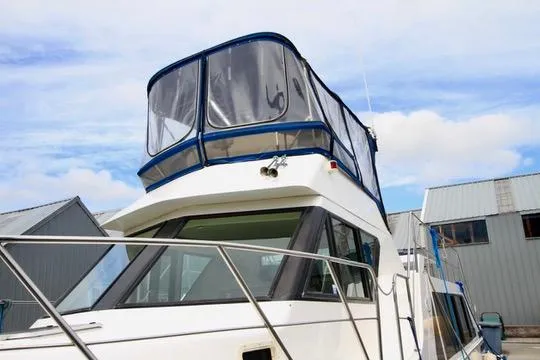 Slide: The Image of 2006 Harbor Master Coastal 400 boat docked near metal buildings under a blue sky. - 6