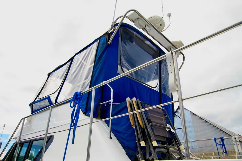 Slide: The Image of 2006 Harbor Master Coastal 400 boat with blue canopy and deck chairs. - 9
