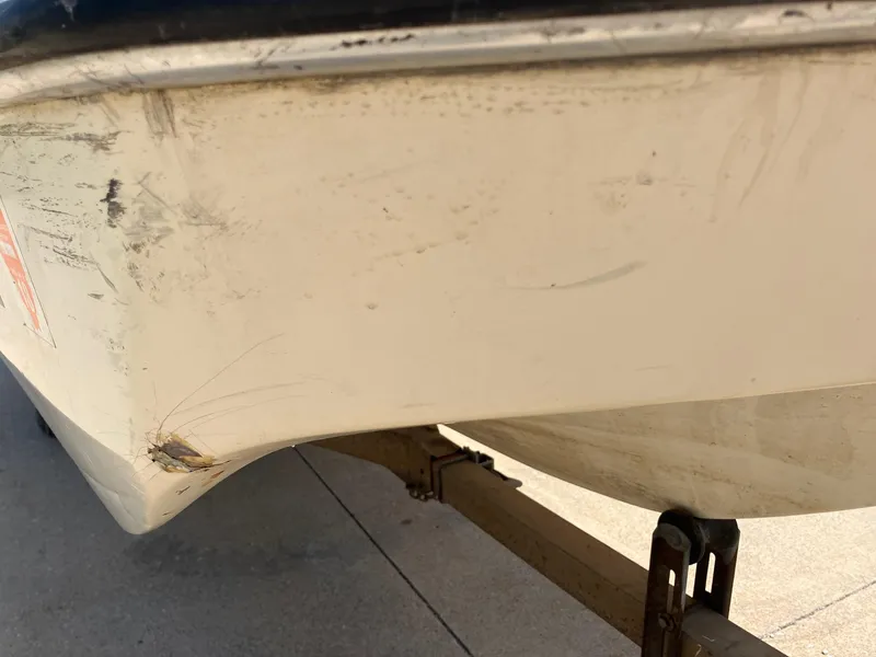 Slide: The Image of 1976 Glastron 156 Open Bow boat with visible hull damage and scratches. - 14