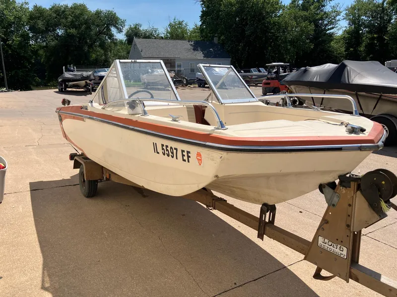 Slide: The Image of 1976 Glastron 156 Open Bow boat on trailer, parked outdoors. - 2
