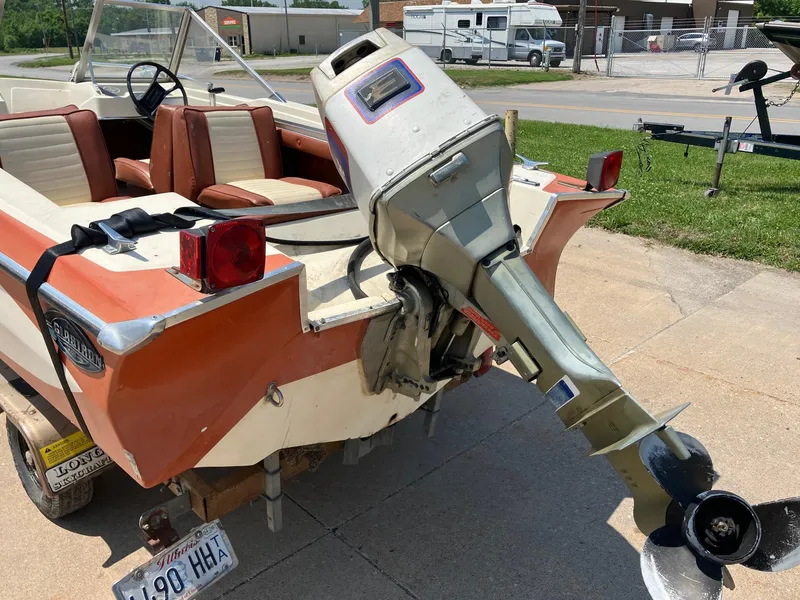 Slide: The Image of 1976 Glastron 156 Open Bow boat with outboard motor, parked on pavement. - 20