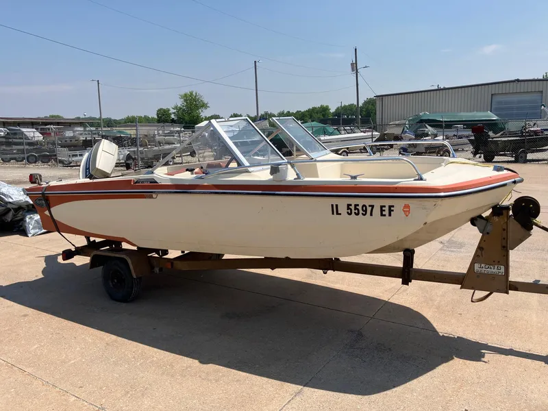 Slide: The Image of 1976 Glastron 156 Open Bow boat on trailer in outdoor setting. - 24
