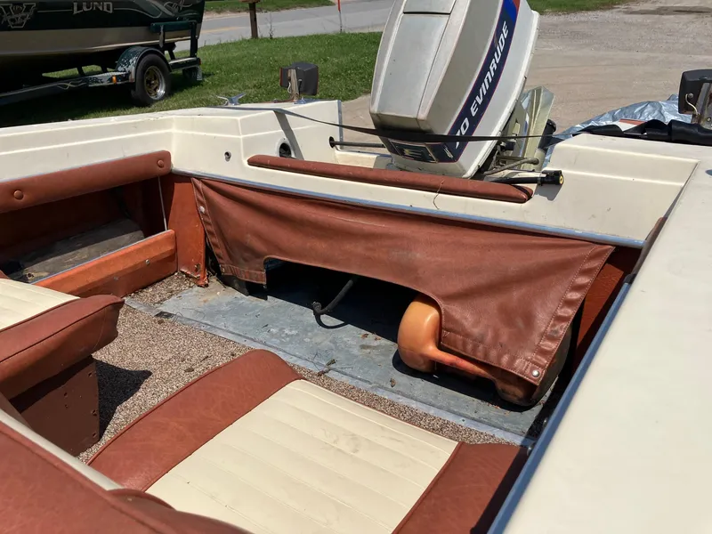 Slide: The Image of 1976 Glastron 156 Open Bow boat interior with Evinrude motor, brown and white seating. - 29