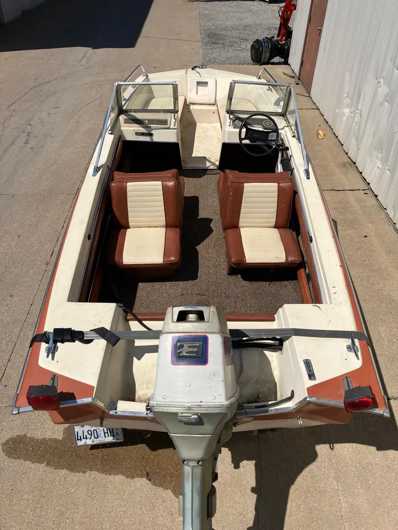 Slide: The Image of 1976 Glastron 156 Open Bow boat with brown and white interior, parked on concrete. - 3