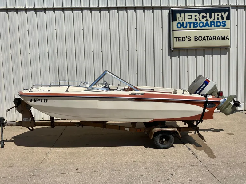 Slide: The Image of 1976 Glastron 156 Open Bow boat on trailer, parked outside Mercury Outboards dealership. - 31
