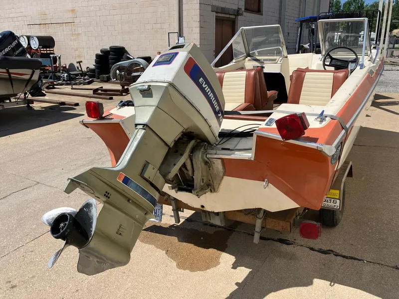 Slide: The Image of 1976 Glastron 156 Open Bow boat with Evinrude motor, parked outdoors. - 32