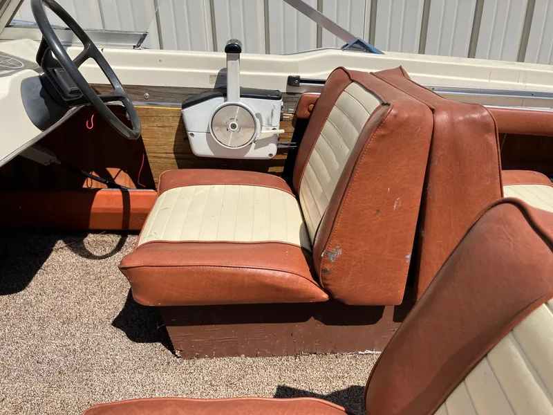 Slide: The Image of 1976 Glastron 156 Open Bow interior with vintage brown and cream seats, steering wheel, and controls. - 4
