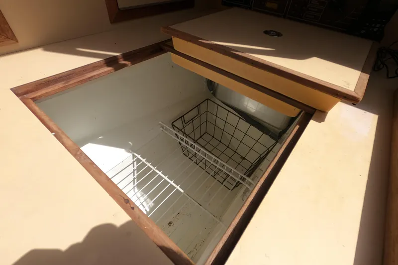 Slide: The Image of Open storage compartment with wire basket in 1984 CAL 31 boat interior. - 10