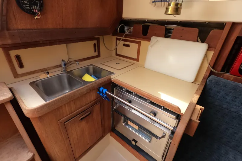 Slide: The Image of Compact kitchen area in a 1984 CAL 31 sailboat with sink, stove, and storage. - 12