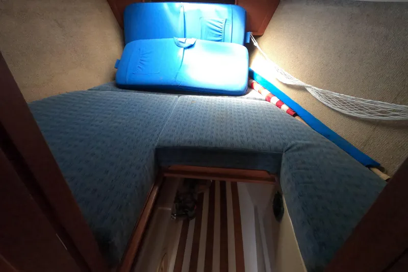Slide: The Image of Cozy cabin interior of 1984 CAL 31 sailboat with blue cushions and storage net. - 18
