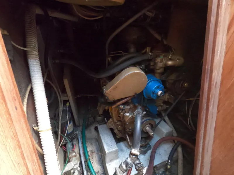 Slide: The Image of Engine compartment of a 1984 CAL 31 sailboat, showing mechanical components and hoses. - 20