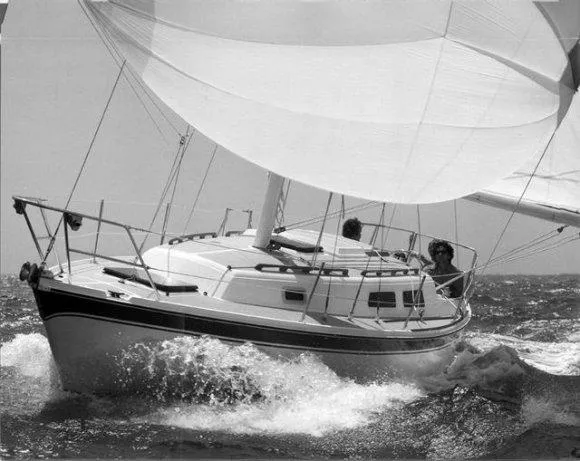 Slide: The Image of Sailboat CAL 31 from 1984 navigating through waves with full sails. - 22