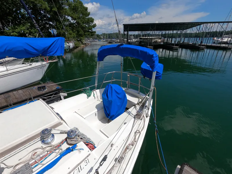 Slide: The Image of Sailboat CAL 31, 1984 model, docked at marina with blue covers. - 4