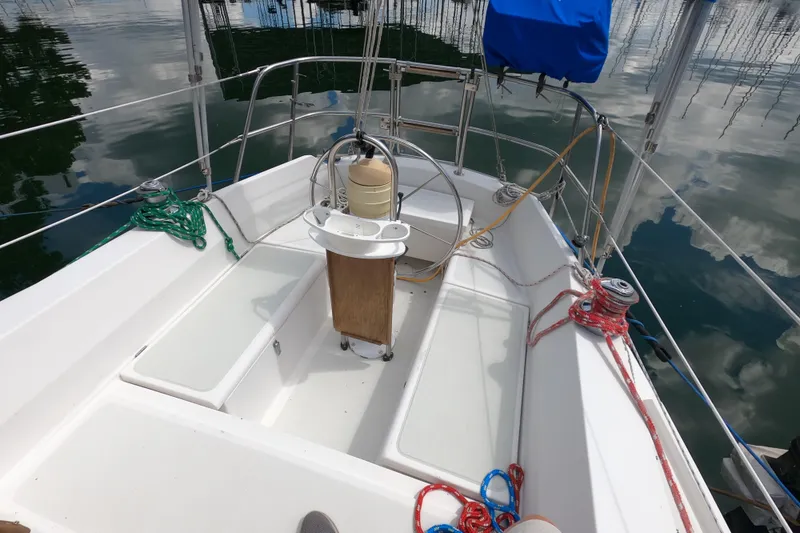 Slide: The Image of Cockpit of 1984 CAL 31 sailboat with ropes and steering wheel, docked on calm water. - 5