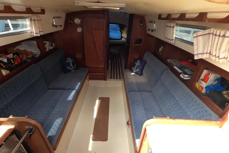 Slide: The Image of Interior of a 1984 CAL 31 sailboat with blue seating and wooden accents. - 7