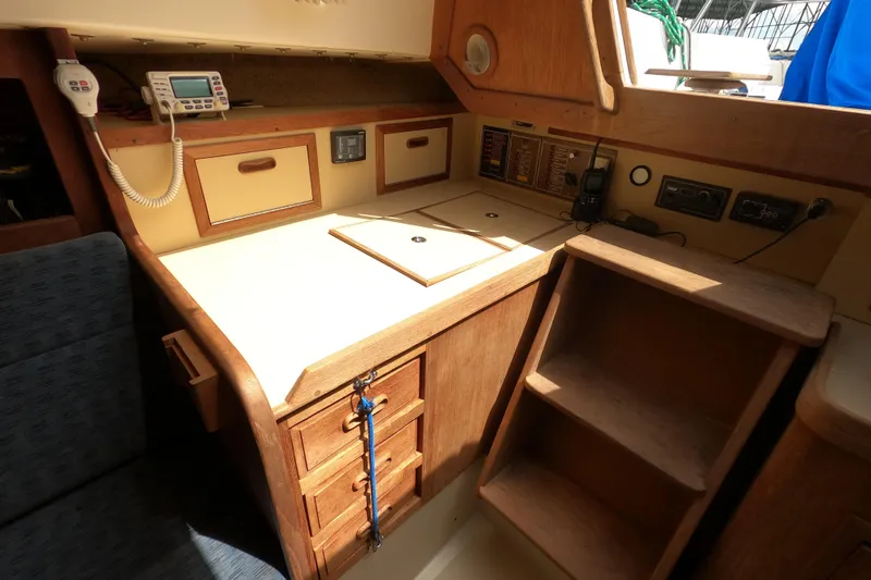 Slide: The Image of 1984 CAL 31 sailboat interior with navigation station, radio, and wooden cabinetry. - 8