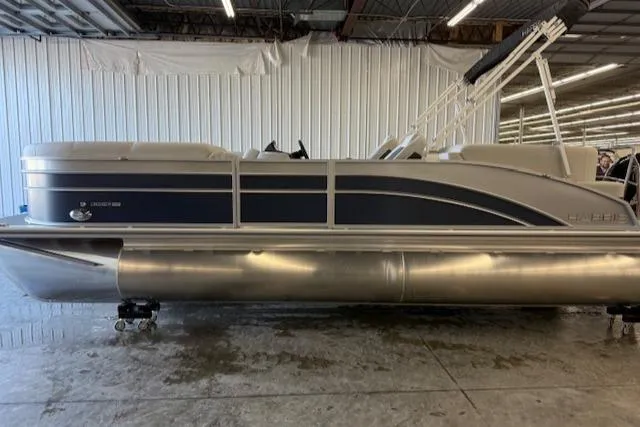 The Image of 2025 Harris Cruiser 230 CWDH pontoon boat in indoor storage facility. - 1