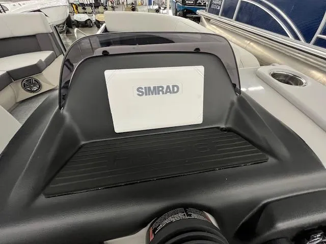 Slide: The Image of 2025 Harris Cruiser 210 boat dashboard with Simrad display in a showroom. - 11