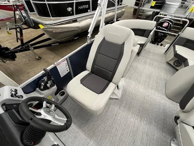 Slide: The Image of 2025 Harris Cruiser 210 boat interior with modern seating and steering console. - 13