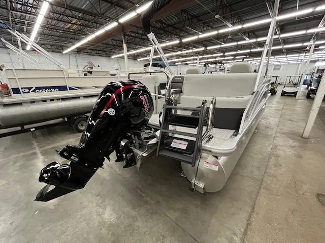 Slide: The Image of 2025 Harris Cruiser 210 pontoon boat with outboard motor in a showroom. - 24