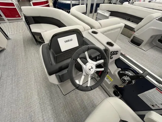Slide: The Image of 2025 Harris Cruiser 210 boat interior with steering wheel and Simrad display. - 3
