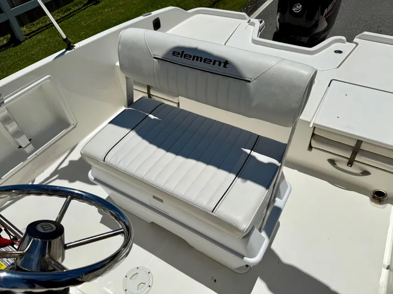 Slide: The Image of 2020 Bayliner Element F21 boat interior with white seating and steering wheel. - 10