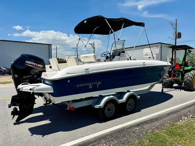Slide: The Image of 2020 Bayliner Element F21 boat on trailer with Mercury engine, parked outdoors. - 4