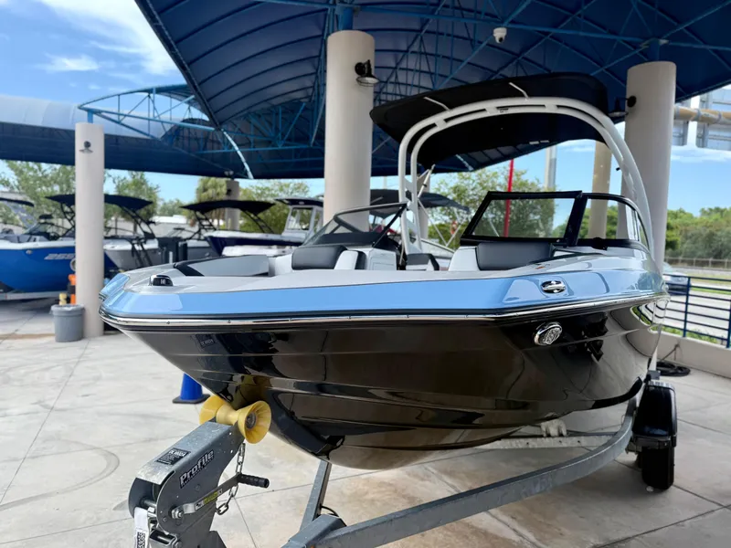 Slide: The Image of 2025 Yamaha Boats 195S on trailer under blue canopy, sleek design. - 2
