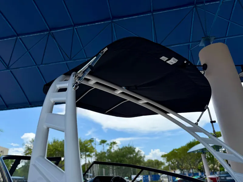 Slide: The Image of 2025 Yamaha Boats 195S with canopy under blue structure, showcasing sleek design. - 4