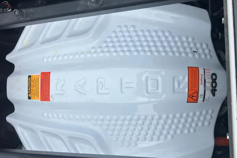 Slide: The Image of 2023 Tigé Z1 boat engine cover with Raptor branding and caution labels. - 15