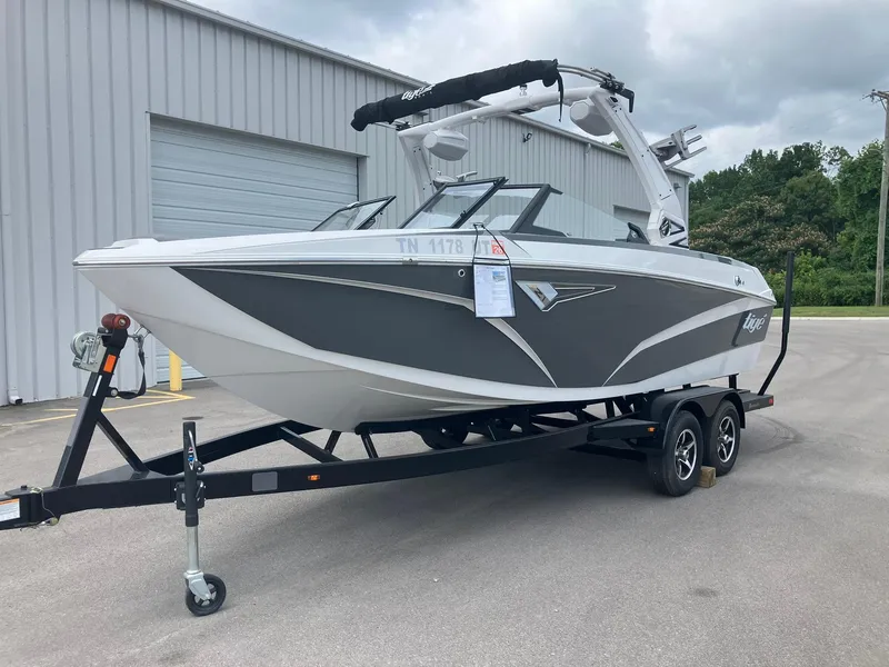 Slide: The Image of 2023 Tigé Z1 boat on trailer, parked outside a warehouse. - 5