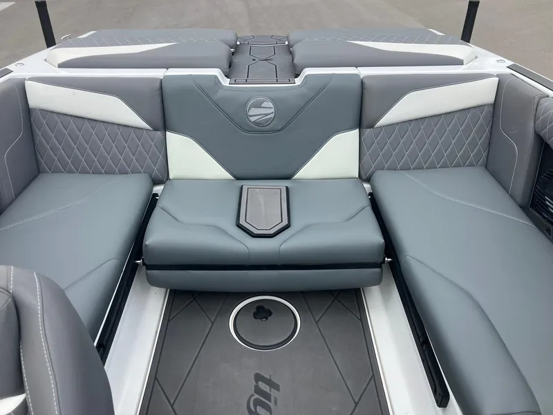 Slide: The Image of 2023 Tigé Z1 boat interior with gray and white seating, diamond stitching, and central table. - 7