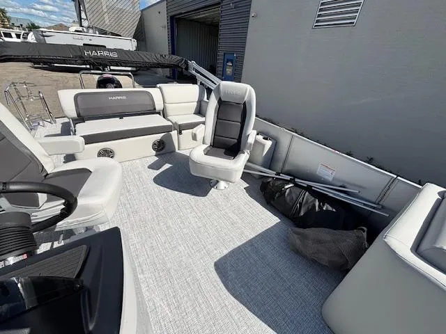 Slide: The Image of 2025 Harris Cruiser 210 pontoon boat interior with seating and storage, docked outdoors. - 20