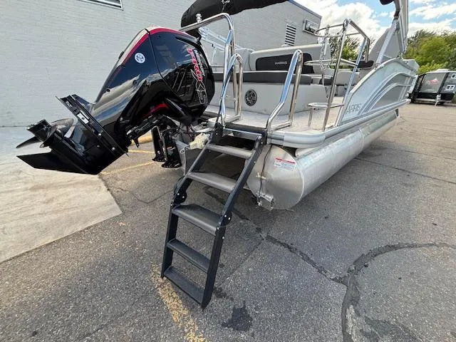 Slide: The Image of 2025 Harris Cruiser 210 pontoon boat with outboard motor and boarding ladder. - 23