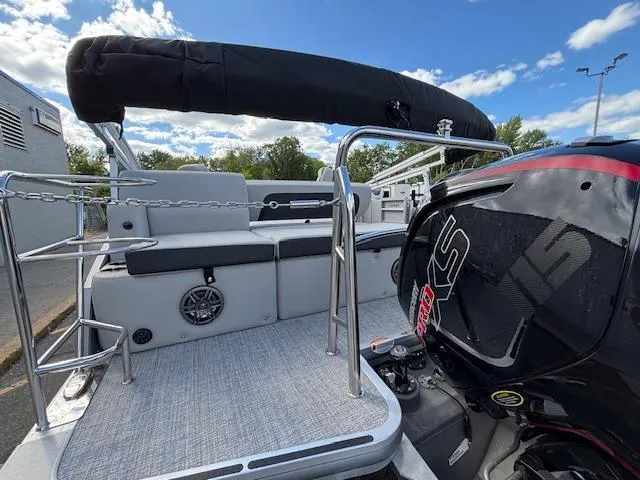 Slide: The Image of 2025 Harris Cruiser 210 pontoon boat with sleek design and powerful engine, under a clear sky. - 26