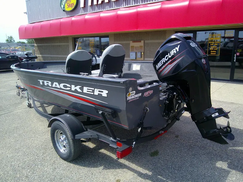 Slide: The Image of 2017 Tracker Pro Guide V-16 SC boat with Mercury engine, parked outside a store. - 4
