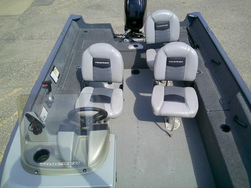 Slide: The Image of 2017 Tracker Pro Guide V-16 SC boat interior with four gray seats and steering console. - 7