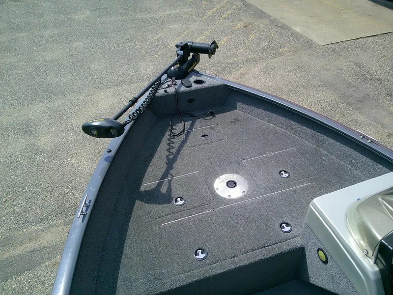 Slide: The Image of 2017 Tracker Pro Guide V-16 SC boat deck with trolling motor, parked on pavement. - 9