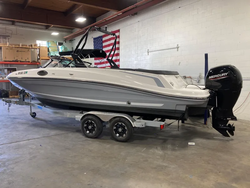 Slide: The Image of 2020 Bayliner VR6 boat on trailer in indoor storage with American flag backdrop. - 13