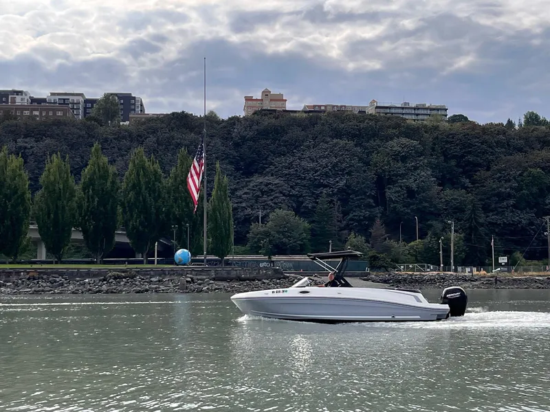 Slide: The Image of 2020 Bayliner VR6 boat cruising on a calm river with a scenic backdrop. - 19