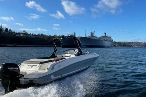 Slide: The Image of 2020 Bayliner VR6 boat cruising on open water with large ship in background. - 23