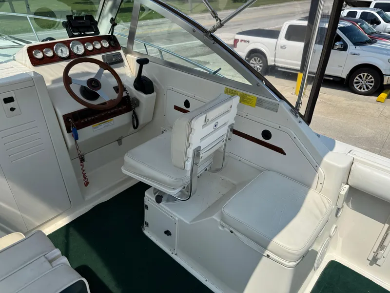 Slide: The Image of 1996 Pursuit 2460 Denali boat cockpit with steering wheel and seating. - 13