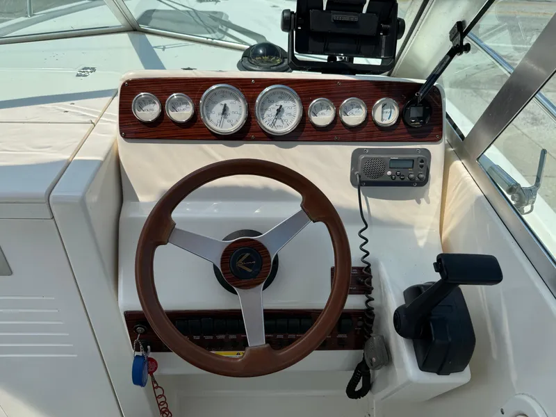 Slide: The Image of 1996 Pursuit 2460 Denali boat dashboard with steering wheel and gauges. - 15